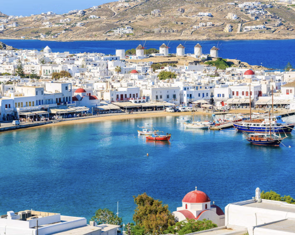 Guests practicing abundance meditation at a luxury retreat in Mykonos with a stunning sea view.